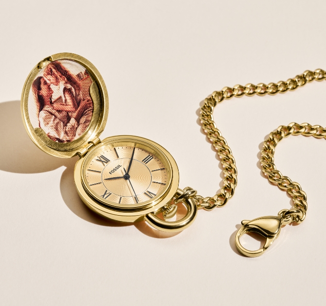 La montre gousset Fossil dorée, qui s’ouvre pour dévoiler une photo d’un côté et un cadran blanc de l’autre.